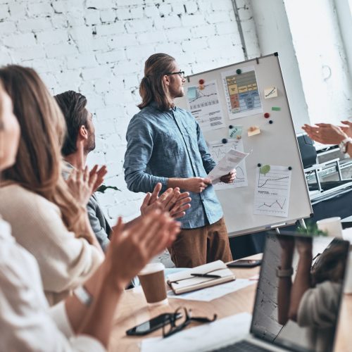 Great work. Group of business people clapping while standing in the board room